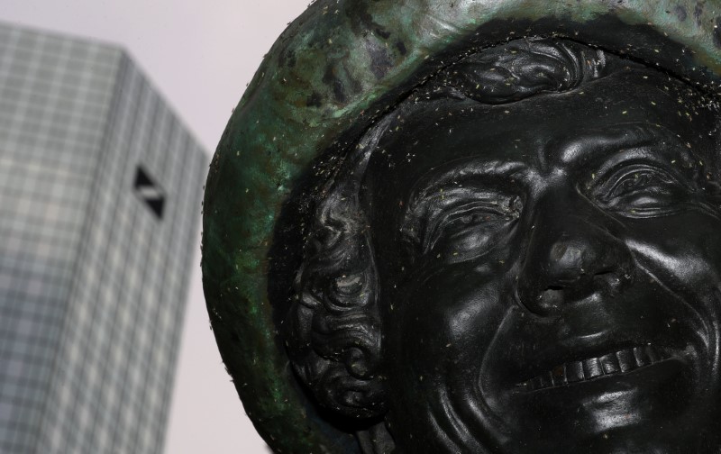 © Reuters. A sculpture of a smiling man is seen next to the headquarters of Germany's largest business bank, Deutsche Bank in Frankfurt