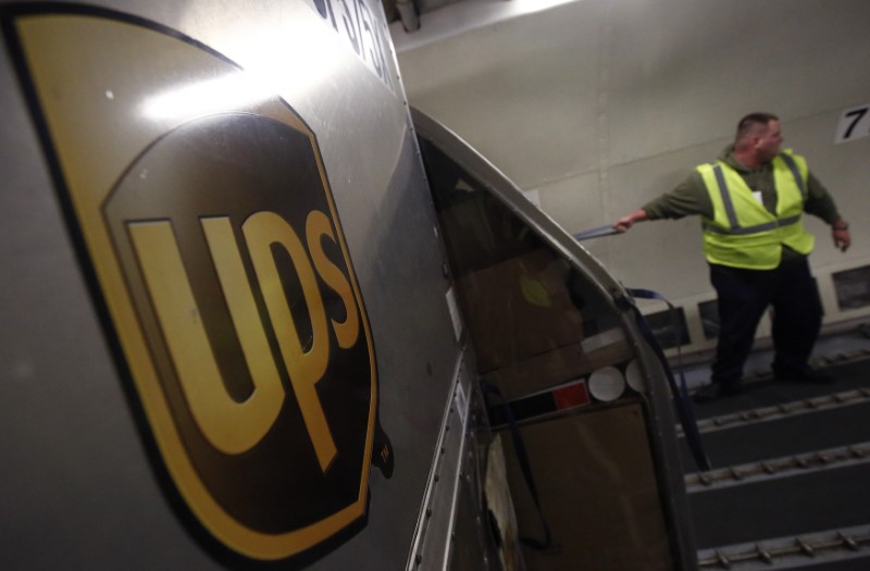 © Reuters. A United Parcel Service (UPS) employee unloads packages from the cargo of an airplane at the Regional Air Hub in Rockford