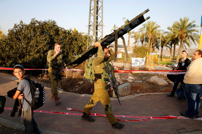 © Reuters. Israeli soldier carries a stretcher at the scene where a Palestinian, who the Israeli military said tried to stab a soldier, was shot dead by Israeli troops near the Jewish settlement of Ofra near Ramallah