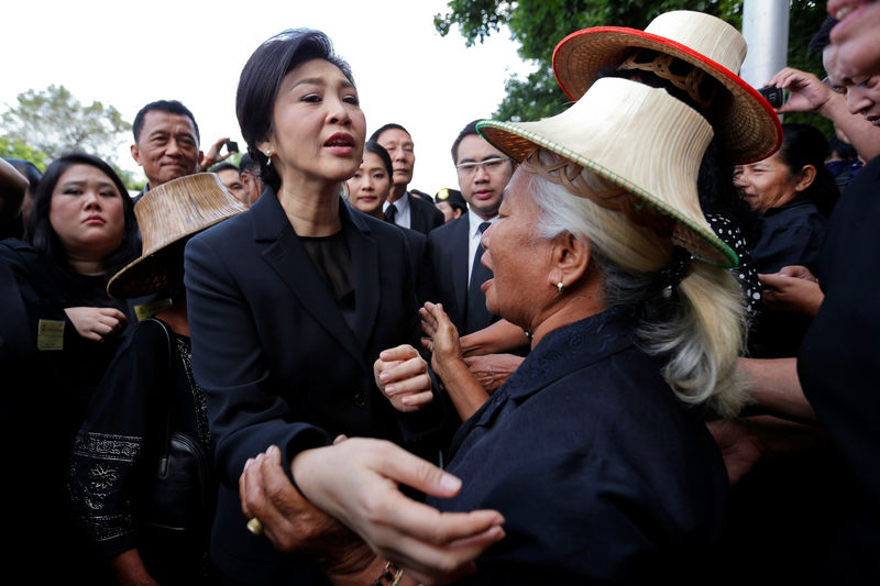 © Reuters. Ousted former Thai Prime Minister Yingluck Shinawatra greets supporters as she arrives at the Supreme Court for a trial on criminal negligence looking into her role in a debt-ridden rice subsidy scheme during her administration, in Bangkok