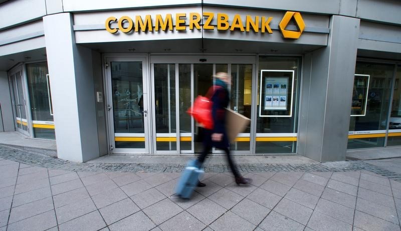 © Reuters. A pedestrian walks past a branch of Commerzbank located in its headquarters before the bank's annual news conference in Frankfurt