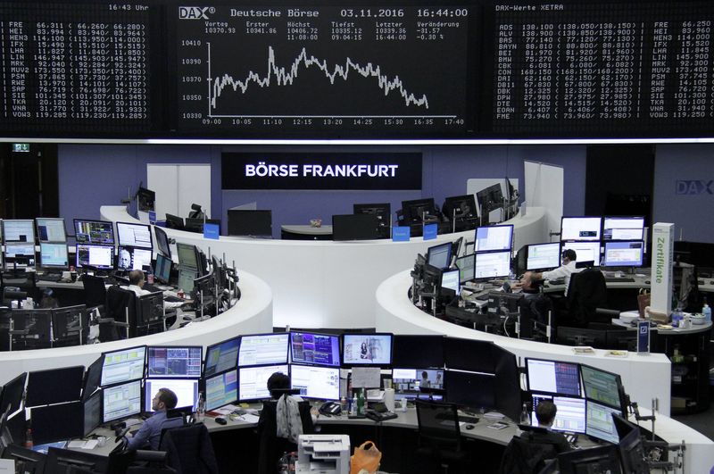 © Reuters. Traders work at their desks in front of the German share price index DAX board in Frankfurt