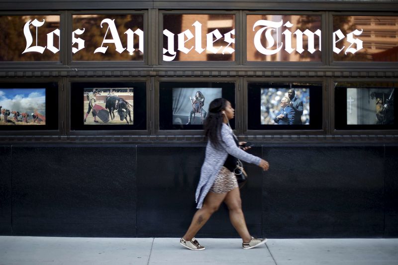 © Reuters. A woman walks past the building of Los Angeles Times newspaper, which is owned by Tribune Publishing Co, in Los Angeles