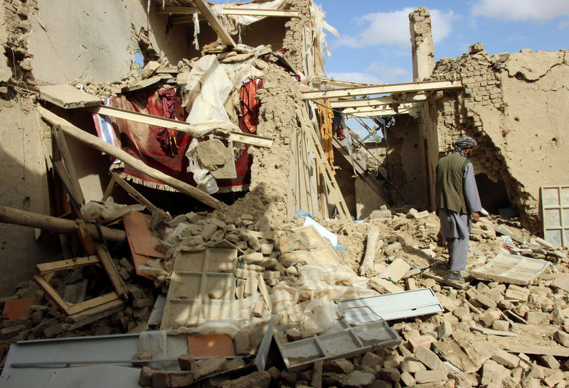 © Reuters. An Afghan man inspects a house destroyed during ThursdayÕs clashes between Afghan security forces and Taliban in Kunduz, Afghanistan