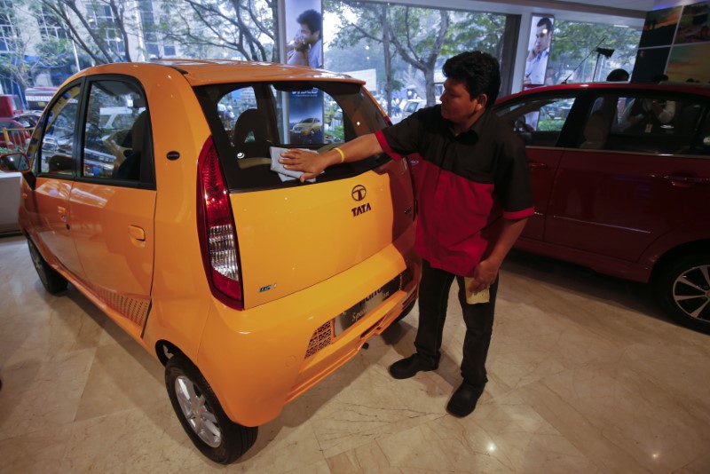 © Reuters. A showroom attendant cleans a Tata Nano car at the flagship Tata Motors showroom before the announcement of their Q3 results in Mumbai