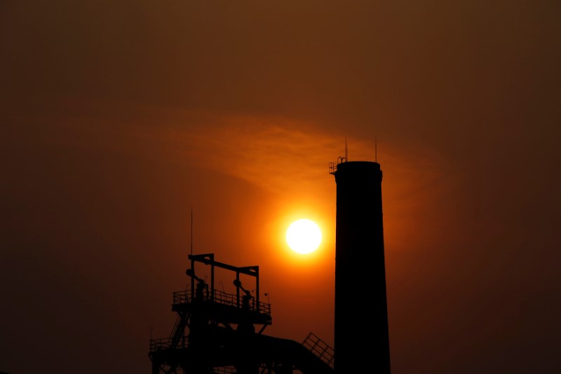 © Reuters. The sun sets behind a chimney of a steel mill in Tangshan, Hebei province