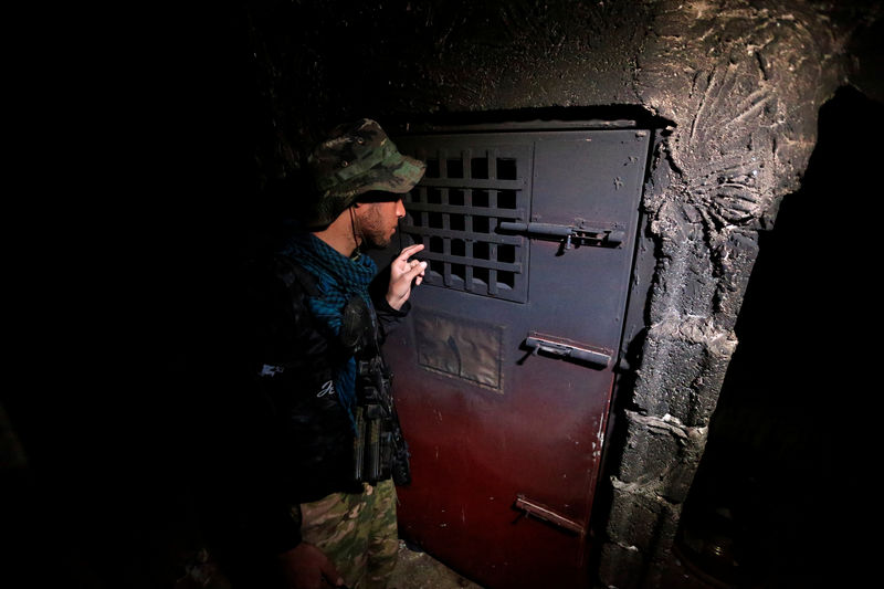 © Reuters. A member of Iraqi security forces inspects a building that was used as a prison by Islamic State militants in Hammam al-Ali, south of Mosul