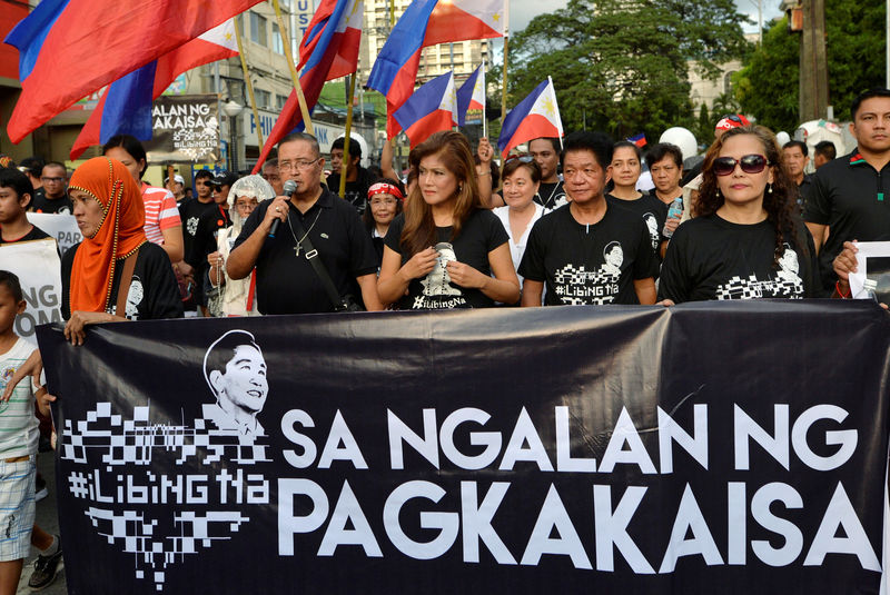 © Reuters. Governor Imee Marcos holds a rosary as she joins other supporters and during a rally in front of the Supreme Court in Manila