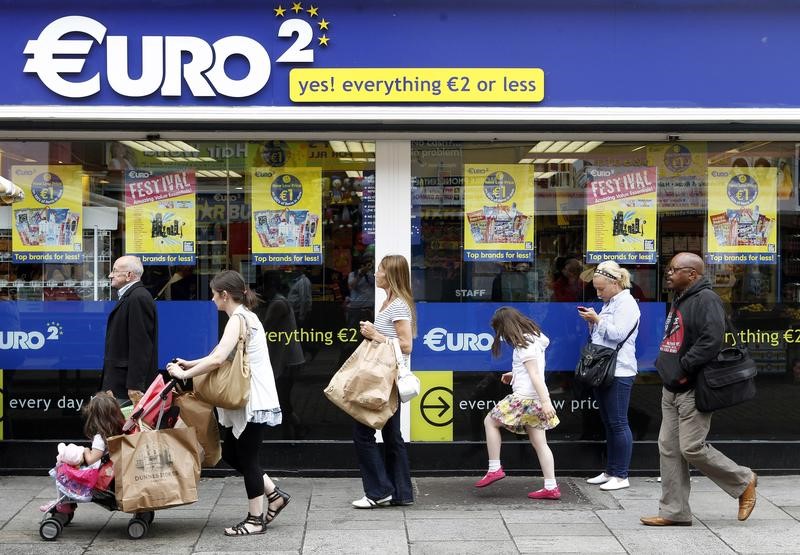 © Reuters. Pedestrian's walk past a discount store on Moore Street in Dublin