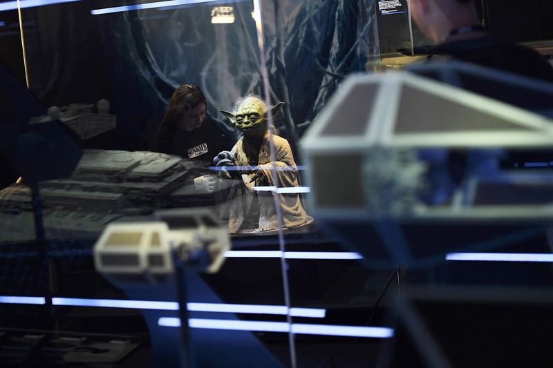 © Reuters. Kathy Smeaton, helps unpack the Yoda puppet used in the original movies, at the Star Wars Identities exhibition at the 02 in London