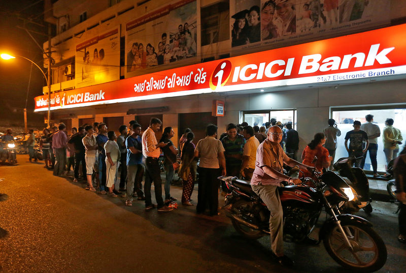 © Reuters. People wait to deposit and withdraw their money outside an ICICI Bank ATM in Rajkot