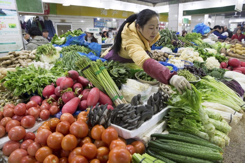 © Reuters. A vendor arranges vegetables at her stall at a market in Nanjing