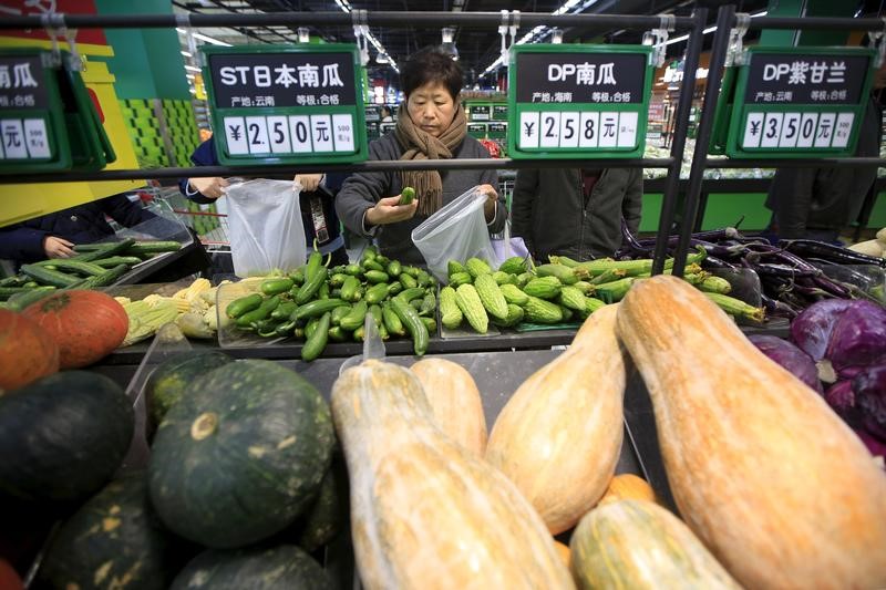 © Reuters. File photo of consumers choosing vegetables at a supermarket in Shanghai