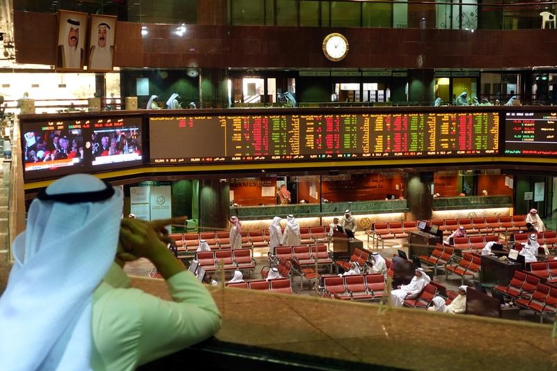 © Reuters. Screens showing U.S. President-elect Donald Trump are seen as traders monitor stock information at the Borsa Kuwait Stock Exchange, in Kuwait City