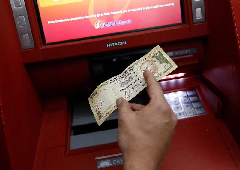 © Reuters. A customer deposits 500 Indian rupee banknote in a cash deposit machine in Mumbai