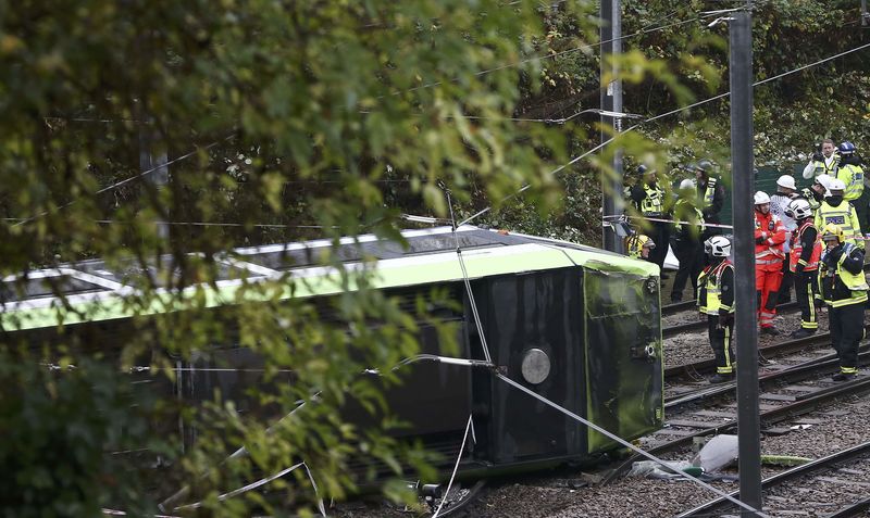 © Reuters. Membros dos serviços de resgate ao lado de bonde virado em Croydon