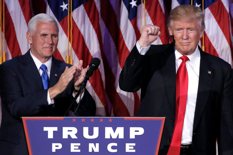 © Reuters. U.S. President-elect Donald Trump gestures as Vice President-elect Mike Pence applaud at their election night rally in Manhattan, New York