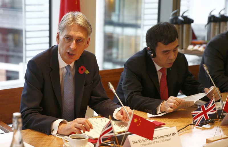 © Reuters. Britain's Chancellor of the Exchequer Philip Hammond speaks at a round-table meeting with Tian Guoli (R) of the Bank of China at the London Stock Exchange