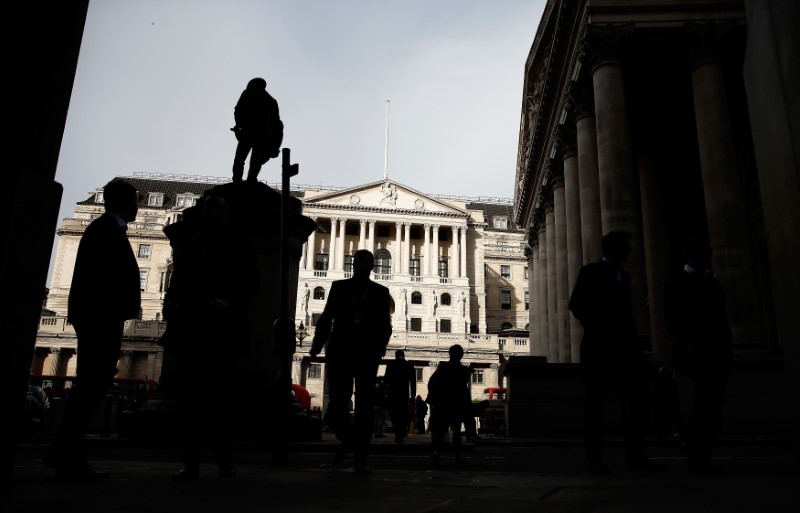 © Reuters. Pedestrians are silhouetted as the winter sun shines on to front of the Bank of England in the City of London