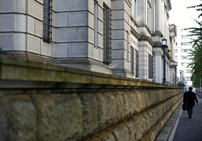 © Reuters. A man walks past the Bank of Japan building in Tokyo