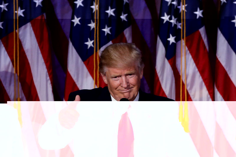 © Reuters. Republican presidential nominee Donald Trump holds up a rainbow flag with "LGBTs for TRUMP" written on it at a campaign rally in Greeley