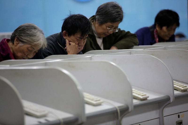 © Reuters. Investors look at screens showing stock information at a brokerage house in Shanghai