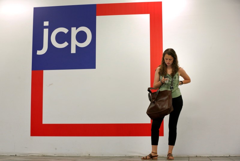 © Reuters. Woman checks her phone outside the entrance of a J.C. Penney store in New York