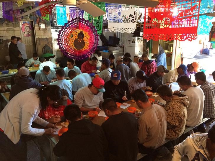 © Reuters. Imigrantes tomam café em centro de Nogales, no México