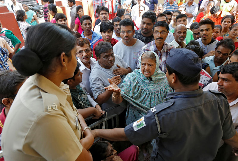 © Reuters. People argue with the security after they are stopped from entering a bank in Mumbai
