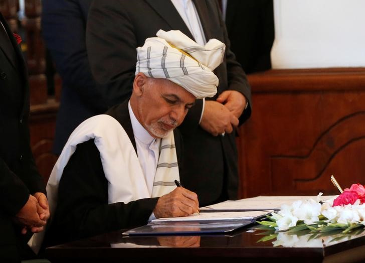 © Reuters. Afghan President Ashraf Ghani, signs a peace agreement with Hizb-i-Islami, led by Gulbuddin Hekmatyar, in Kabul