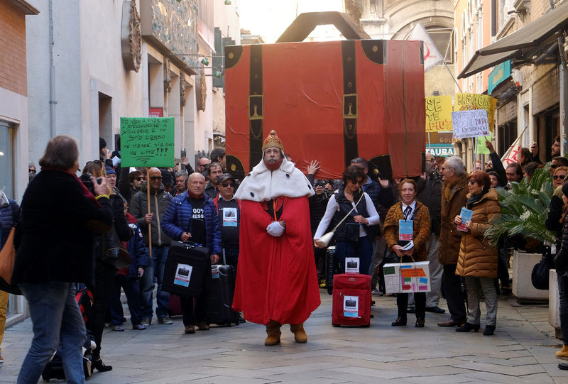 © Reuters. Un grupo de venecianos lleva sus maletas en una protesta para pedir que las autoridades se ocupen más de los residentes de la ciudad italiana y no solo de los turistas.