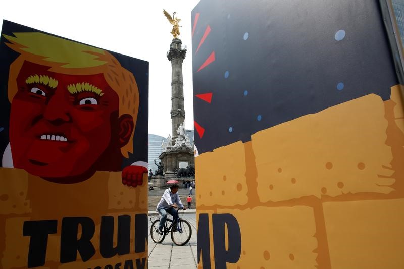 © Reuters. The Angel of Independence monument is seen near a wooden wall with a caricature depicting U.S. Republican presidential nominee Donald Trump after a campaign encouraging U.S. citizens in Mexico to register to vote against Trump, in Mexico City