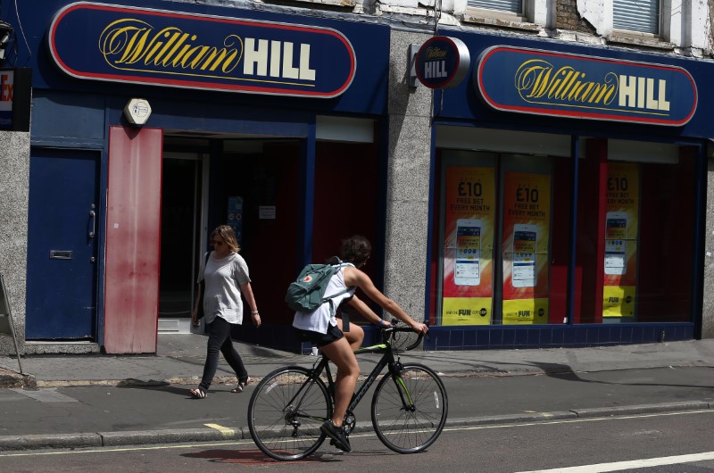 © Reuters. A cyclist passes a William Hill betting shop in London