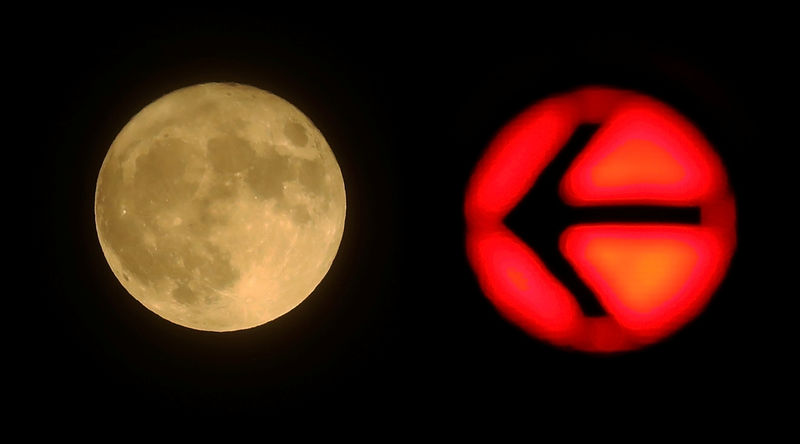 © Reuters. A red traffic light is seen next to the moon in downtown Frankfurt