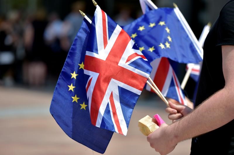 © Reuters. British students hold UK and European Union flags in front of the European Parliament in Brussels