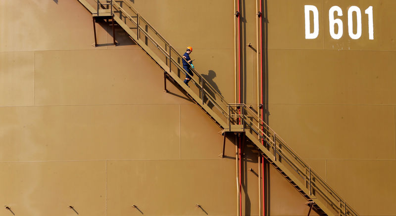 © Reuters. A worker walks down the stairs of an oil tank at Turkey's Mediterranean port of Ceyhan