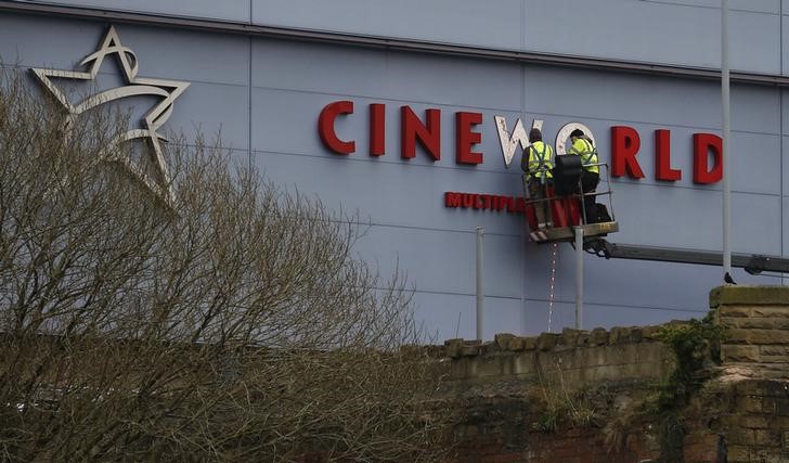 © Reuters. Workers repair a sign at a Cineworld cinema in Bradford northern England.