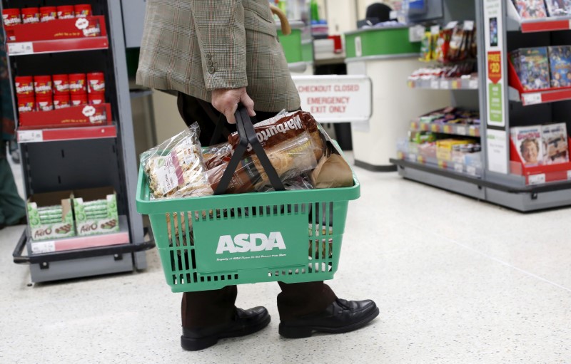 © Reuters. File photograph of a customer carrying a shopping basket at an Asda store in London