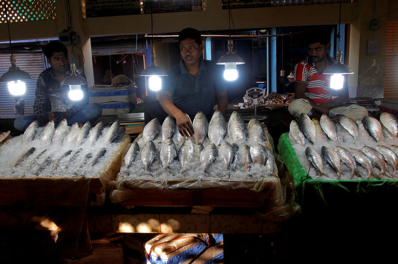 © Reuters. Fish vendors wait for customers at a market in Agartala