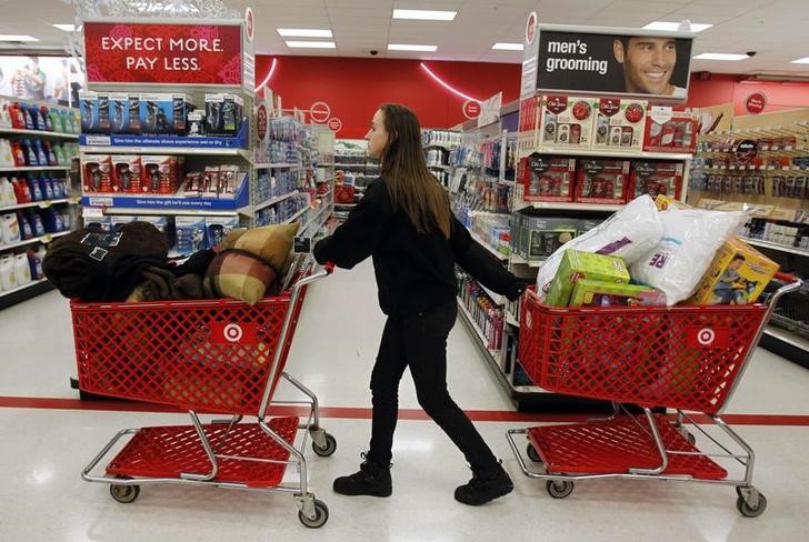 © Reuters. A woman pulls shopping carts through the aisle of a Target store on the shopping day dubbed "Black Friday" in Torrington