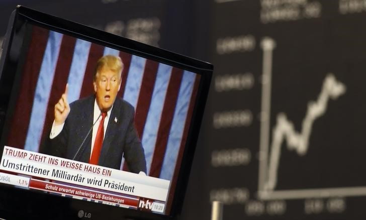 © Reuters. A TV screen showing U.S. President-elect Trump is pictured in front of the German share price index DAX board in Frankfurt