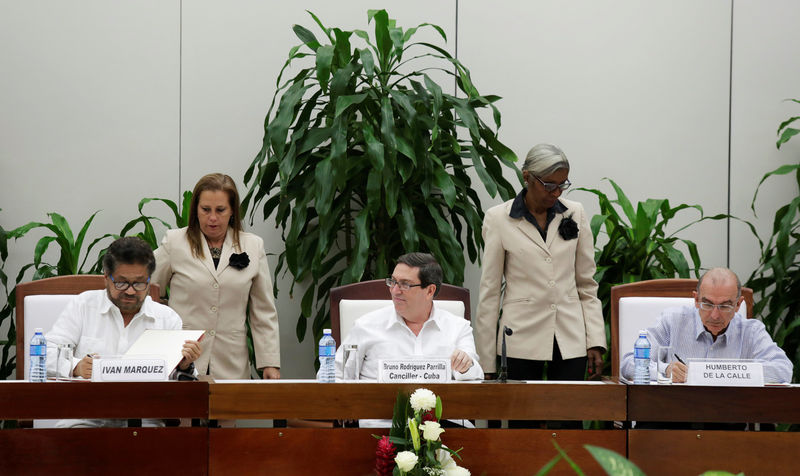 © Reuters. Colombia's FARC lead negotiator Ivan Marquez and Colombia's lead government negotiator Humberto de la Calle sign a new peace deal to end their 52-year war, while Cuba's Foreign Minister Bruno Rodriguez looks on in Havana, Cuba
