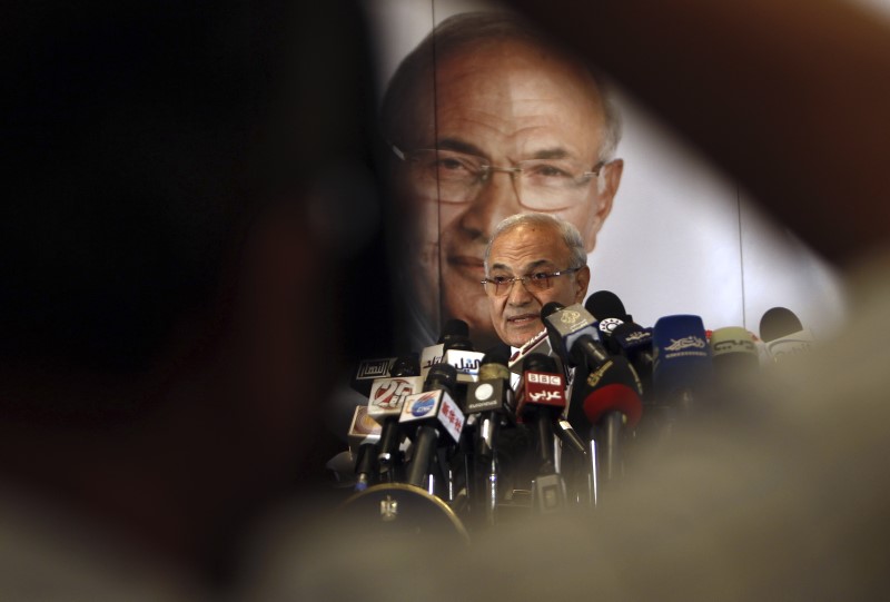 © Reuters. A photographer takes a photo of former Prime Minister and current presidential candidate Ahmed Shafiq during a news conference in Cairo