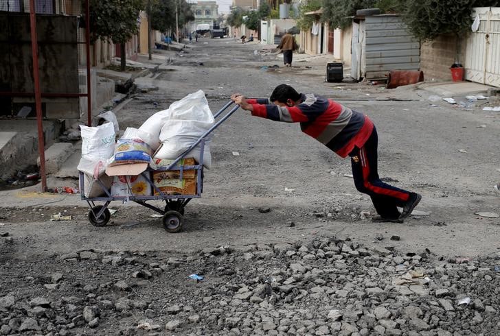 © Reuters. عودة الحياة في بعض أحياء الموصل لكن الخطر ما زال قريبا