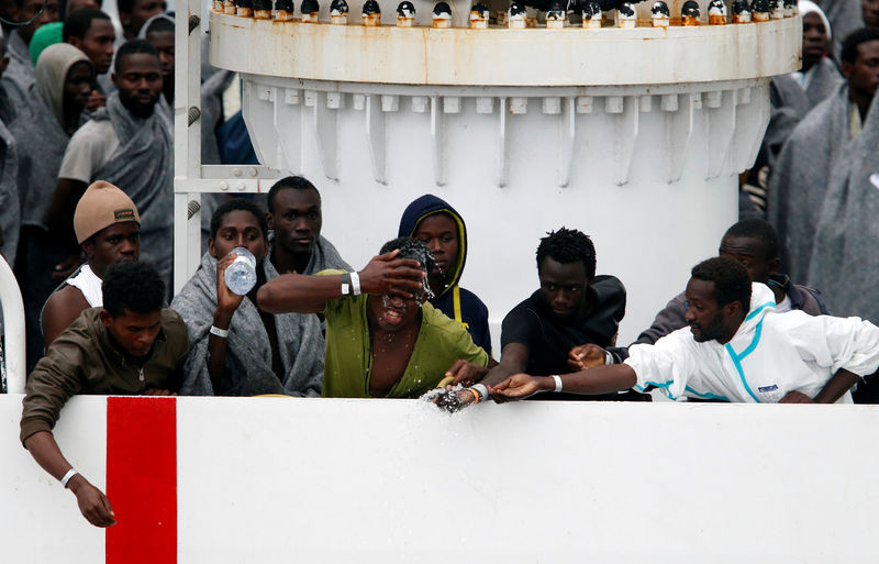 © Reuters. Imigrantes aguardam para desembarcar no porto italiano de Catânia