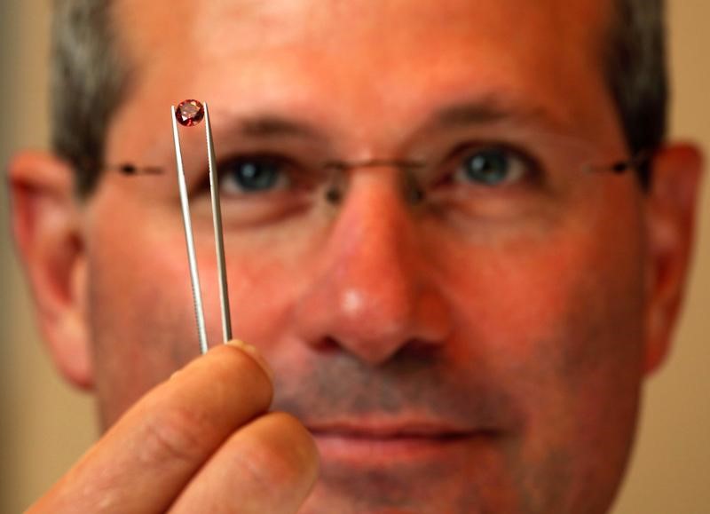 © Reuters. Alan Davies, chief executive of Rio Tinto's diamonds and minerals division, poses with a rare pink diamond in Hong Kong