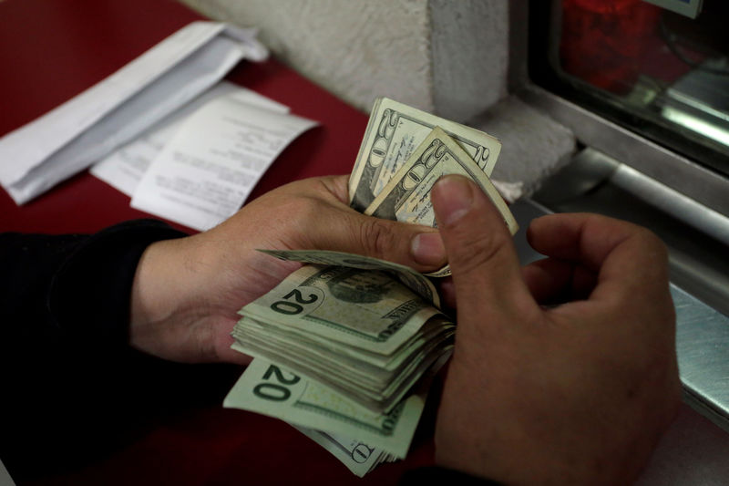 © Reuters. Employee counts U.S. dollar banknotes at a foreign exchange house in Monterrey