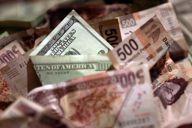 © Reuters. Mexican pesos and U.S. dollar banknotes are seen in this picture illustration
