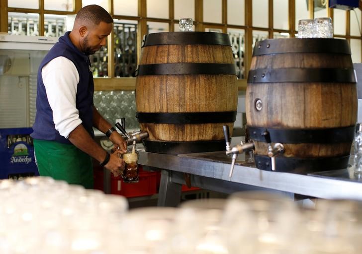 © Reuters. Waiter fills up beer mugs in restaurant at 'Kloster Andechs' in Andechs