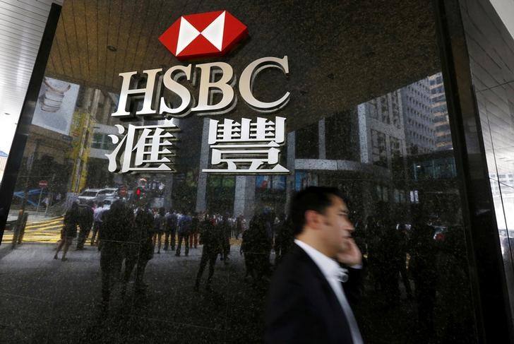 © Reuters. Man walks past a logo of HSBC outside a branch at the financial Central district in Hong Kong